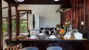 A modern kitchen with a large island, bar stools, and a view of the outdoors. - Sampeah Retreat Villa (Siem Reap)