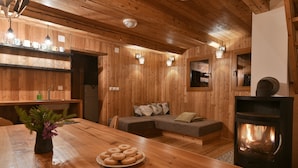 Un interior acogedor de madera con una mesa de comedor, un sofá y una chimenea.