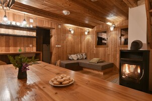 Un interior acogedor de madera con una mesa de comedor, un sofá y una chimenea.