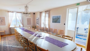 A conference room with a long table, chairs, and a chandelier. - Värdshuset i Motala (Motala)