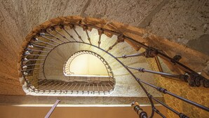 Eine Wendeltreppe mit Metallgeländer und einem kleinen Fenster am oberen Ende.