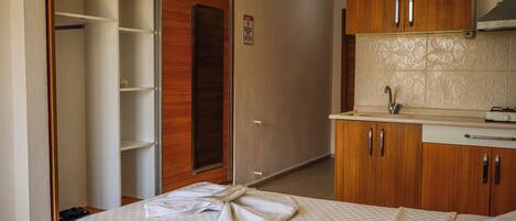 Une chambre d’hôtel avec un lit, une salle de bain avec un lavabo et une armoire.