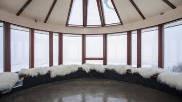 Una habitación con techo abovedado, ventanas amplias y un tragaluz central.