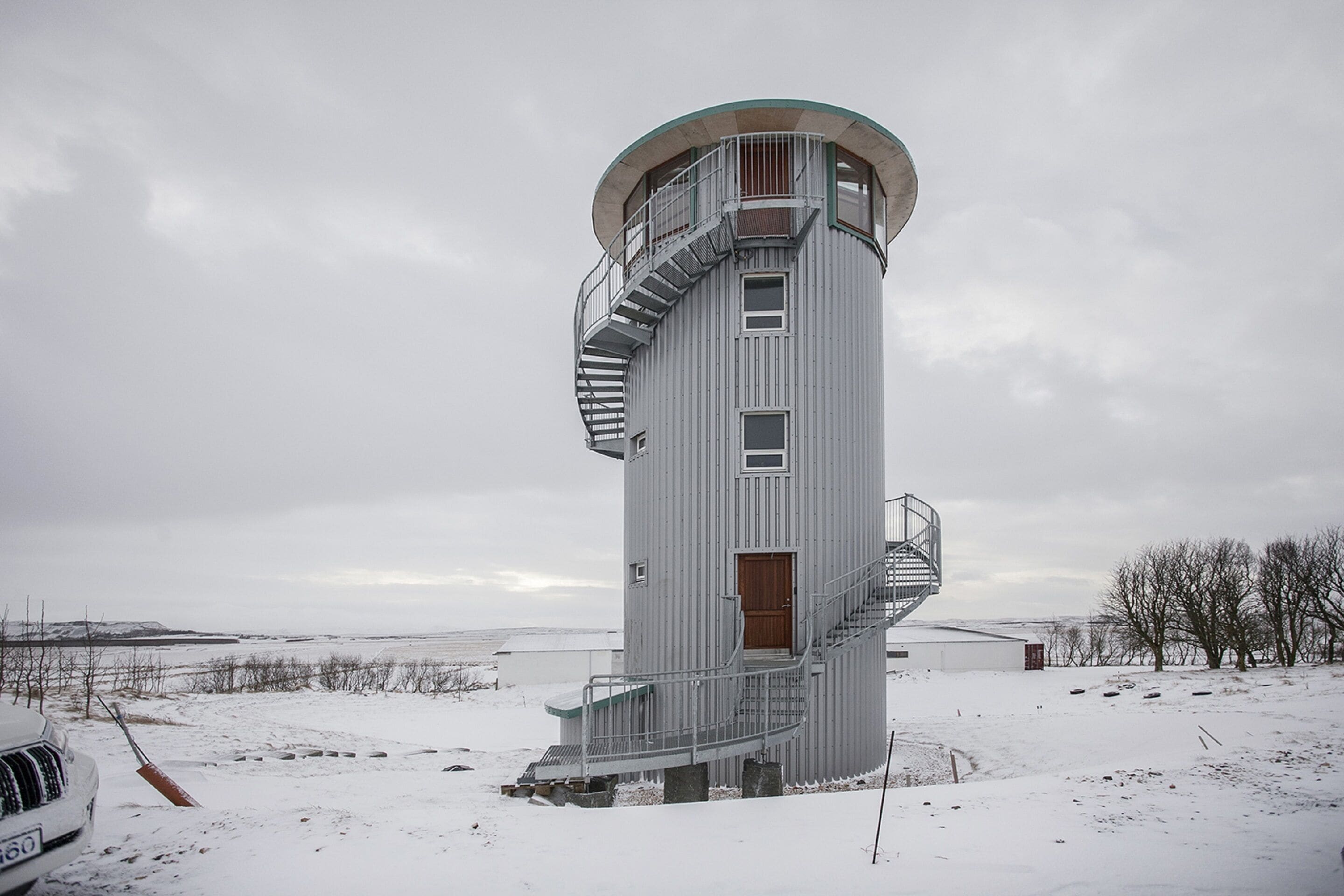 A cylindrical tower with a spiral staircase, a door, and a small window.