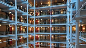 A multi-level atrium with glass railings, multiple floors, and seating areas. - Native Manchester (Manchester)