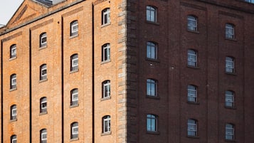 Un edifici de maó de diversos pisos amb teulada plana i nombroses finestres.