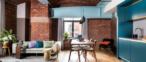 Un espace de vie moderne avec un mur en briques, un plancher en bois et un coin repas comprenant une table et des chaises.