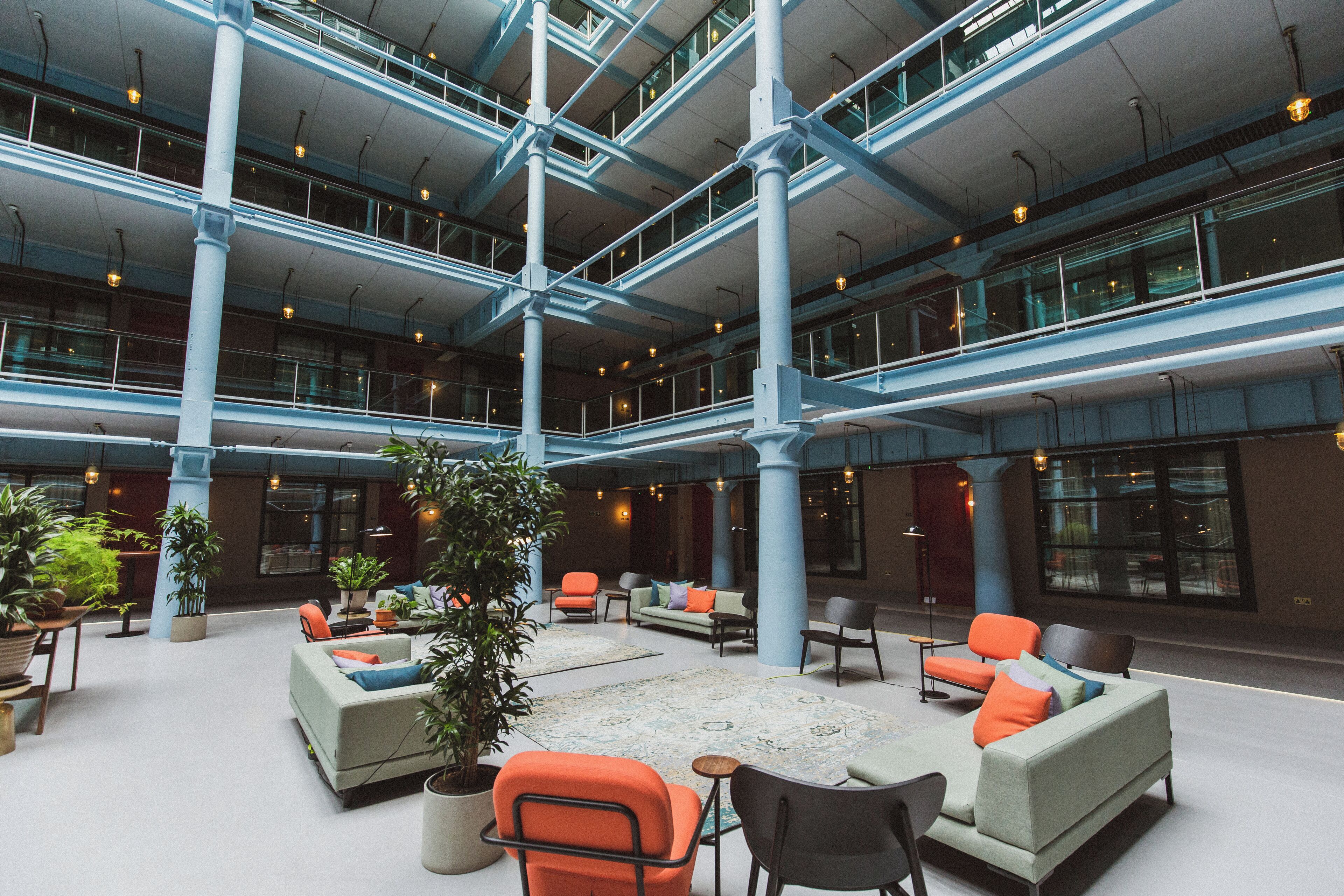 A spacious indoor area with multiple levels, featuring seating arrangements and potted plants.