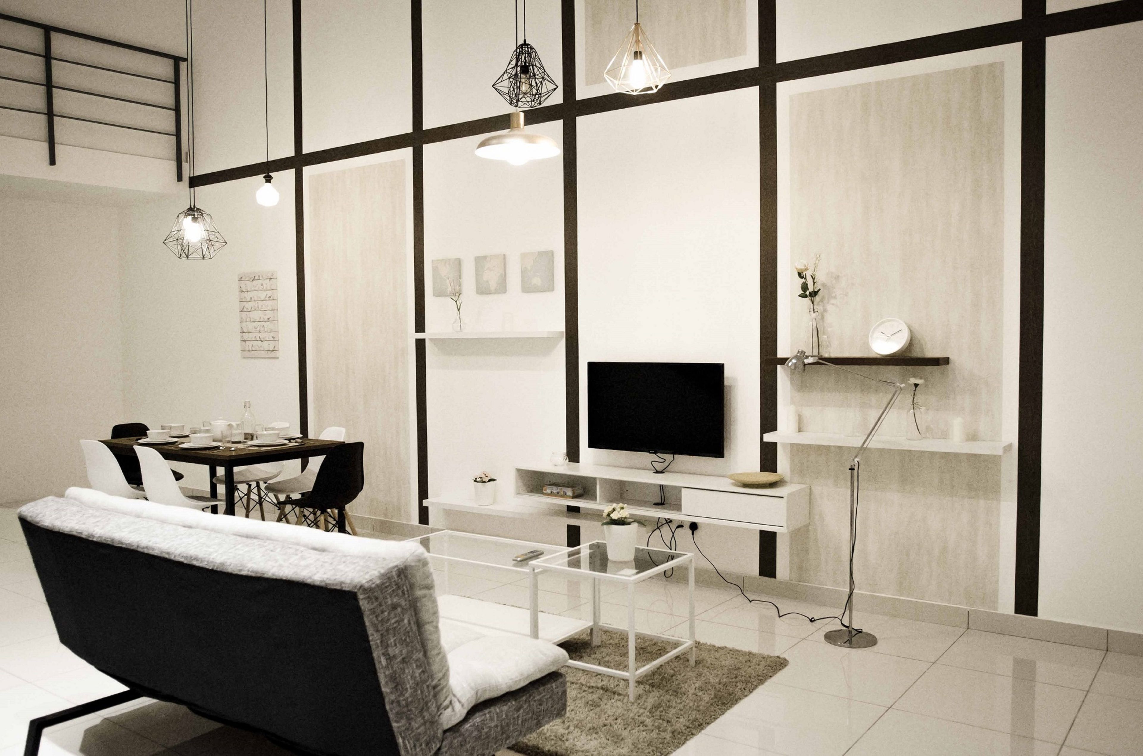 A modern living room with a dining area, a flat-screen TV, and a coffee table.