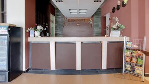 A reception area with a counter, a refrigerator, and a snack rack. - OYO 441 Namira Hotel Syariah (Pogung Lor)