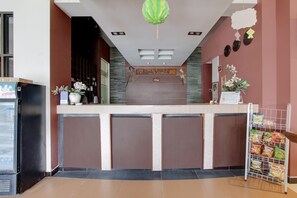 A reception area with a counter, a refrigerator, and a snack rack. - OYO 441 Namira Hotel Syariah (Pogung Lor)