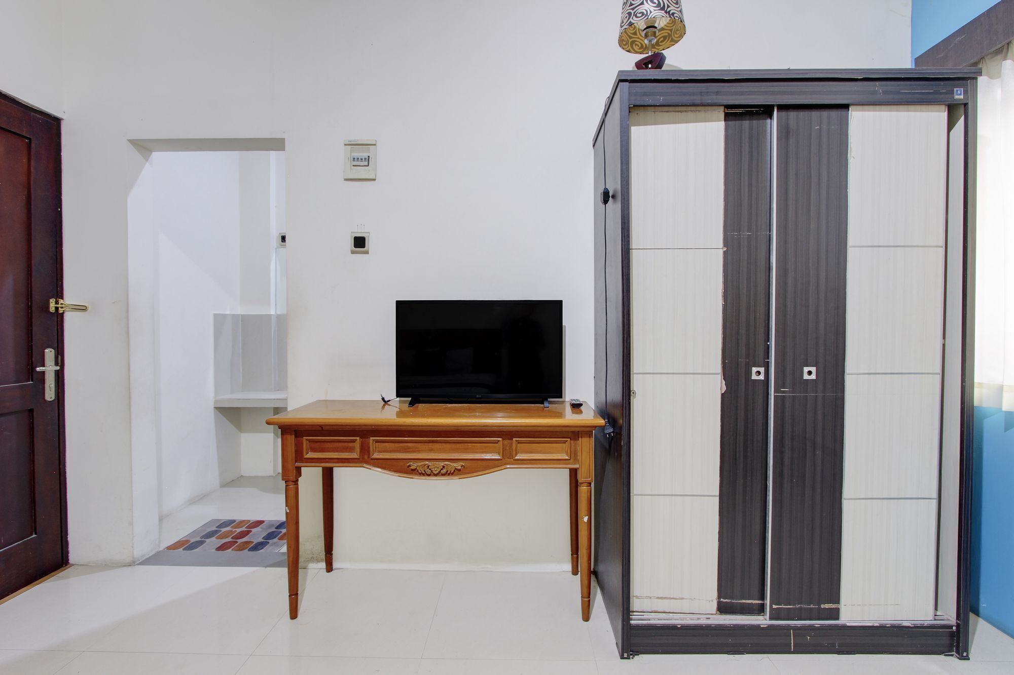 Una habitació amb una taula de fusta, televisió i un armari amb portes corredisses.