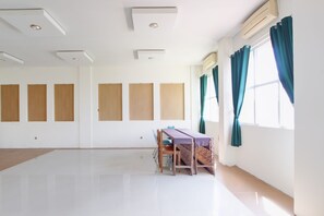A spacious room with a large window, a table, and a chair. - Hotel O near Jogja City Mall formerly Namira Hotel (Pogung Lor)