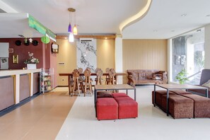 Un interior moderno con mostrador de recepción, mesa de comedor de madera y zona de estar.