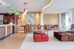 Un interior moderno con mostrador de recepción, mesa de comedor de madera y zona de estar.