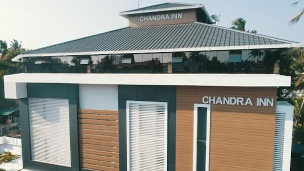 Un bâtiment moderne avec l’enseigne « CHANDRA INN » sur le toit et sur le côté.