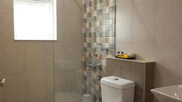 Un baño con ducha, inodoro y lavamanos.