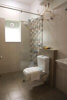 Un baño con ducha, inodoro y lavamanos.