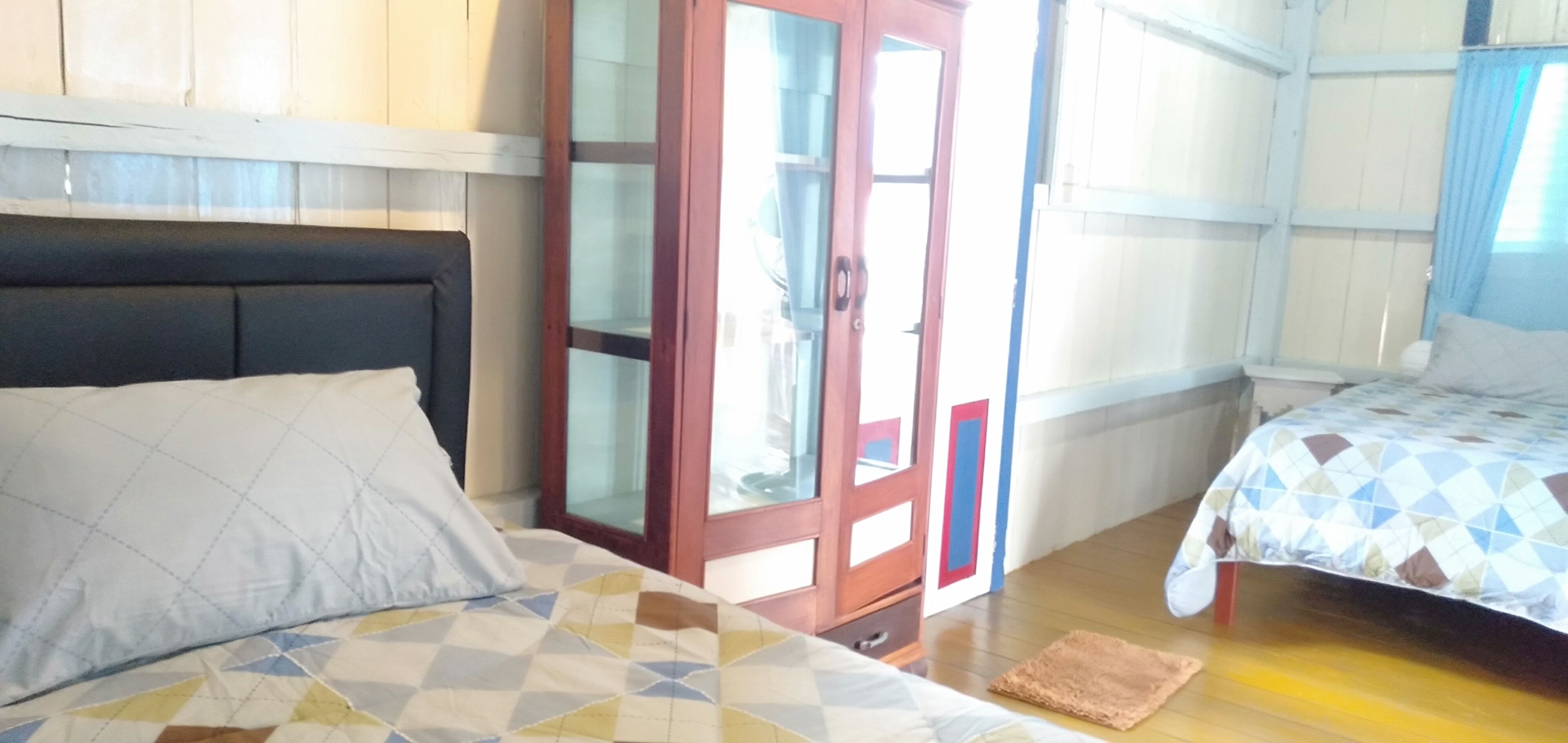 Una habitación con dos camas, un armario y una ventana.
