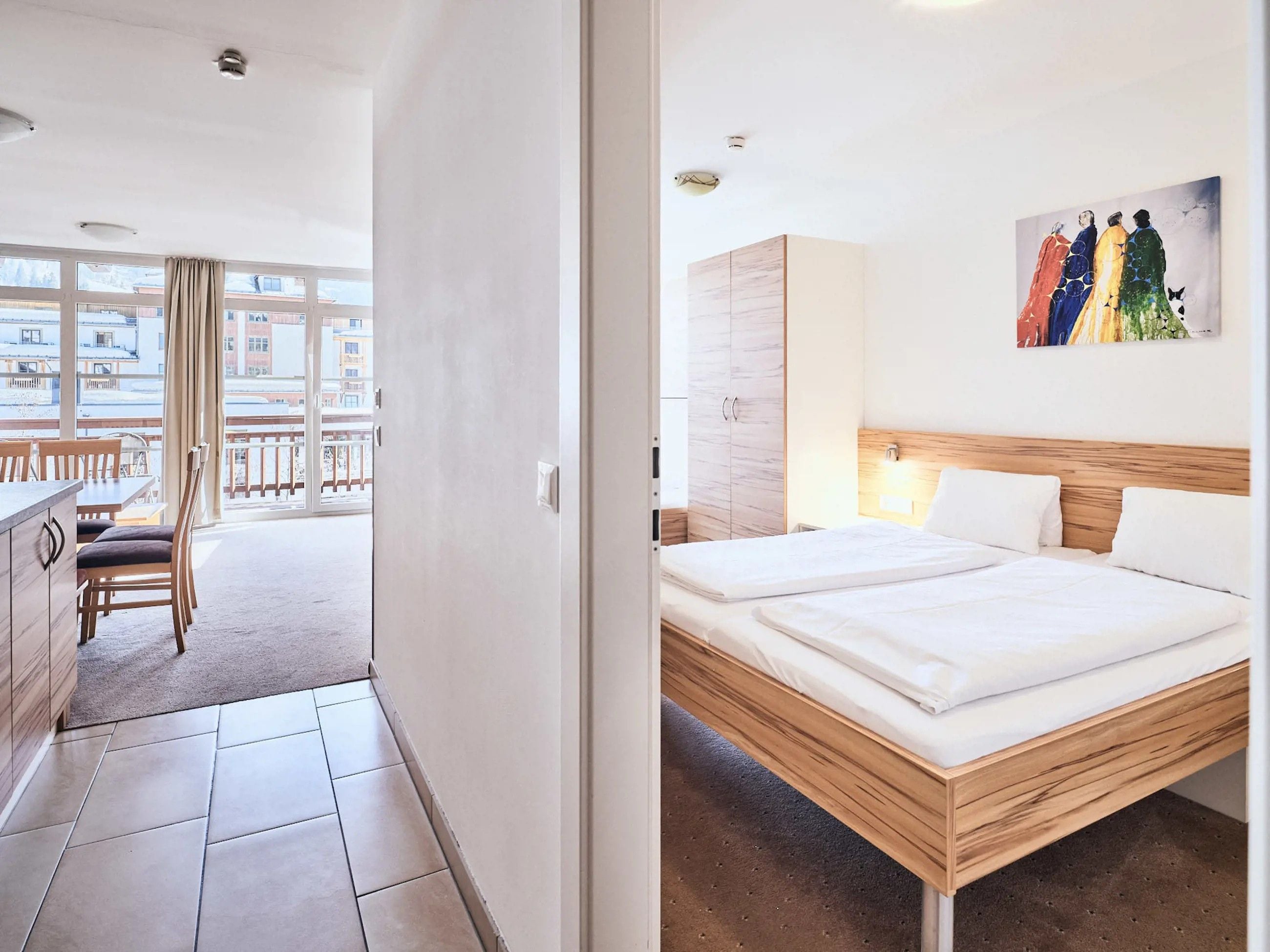 Une chambre d’hôtel avec un lit, un tableau au mur et une vue sur l’extérieur.