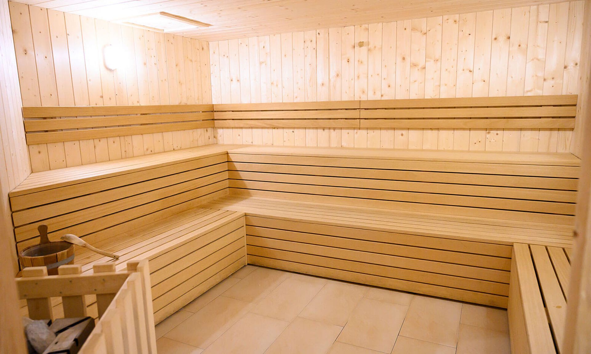 A sauna with wooden benches and a tiled floor.