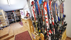 Una tienda de esquí con una variedad de esquíes y equipo para esquiar a la vista.