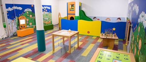 A children's playroom with colorful walls, a play area, and a table with a puzzle.