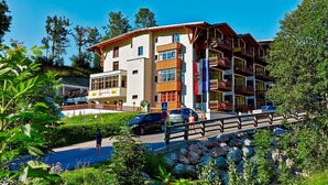 Un hotel de varios pisos con balcones, una bandera y un letrero que indica que es un hotel.