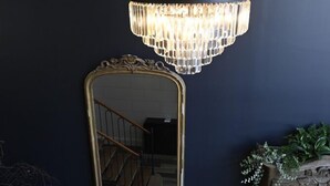 A staircase with wooden steps and a metal railing, leading to a dark wall with a large mirror and a chandelier. - Manoir de l'évêché et Spa (Lisieux)