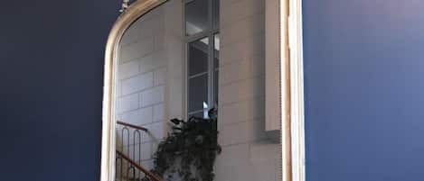 A mirror with an ornate frame on a dark wall.