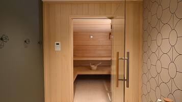 Un sauna de madera con puerta de vidrio, panel de control y pared con diseño.