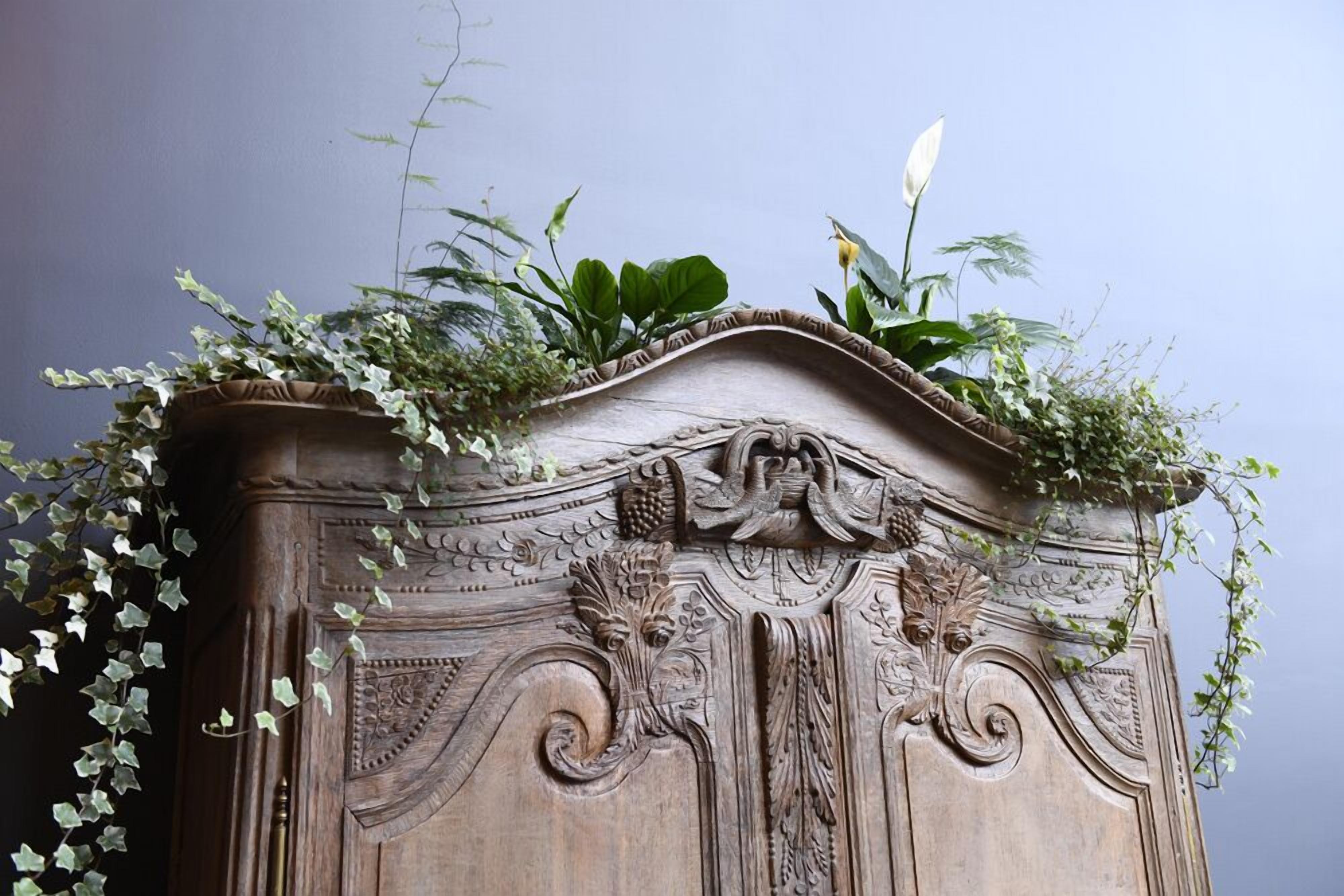 A detailed carved wooden structure with foliage on top.