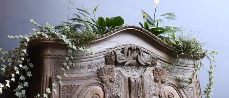 A detailed carved wooden structure with foliage on top.