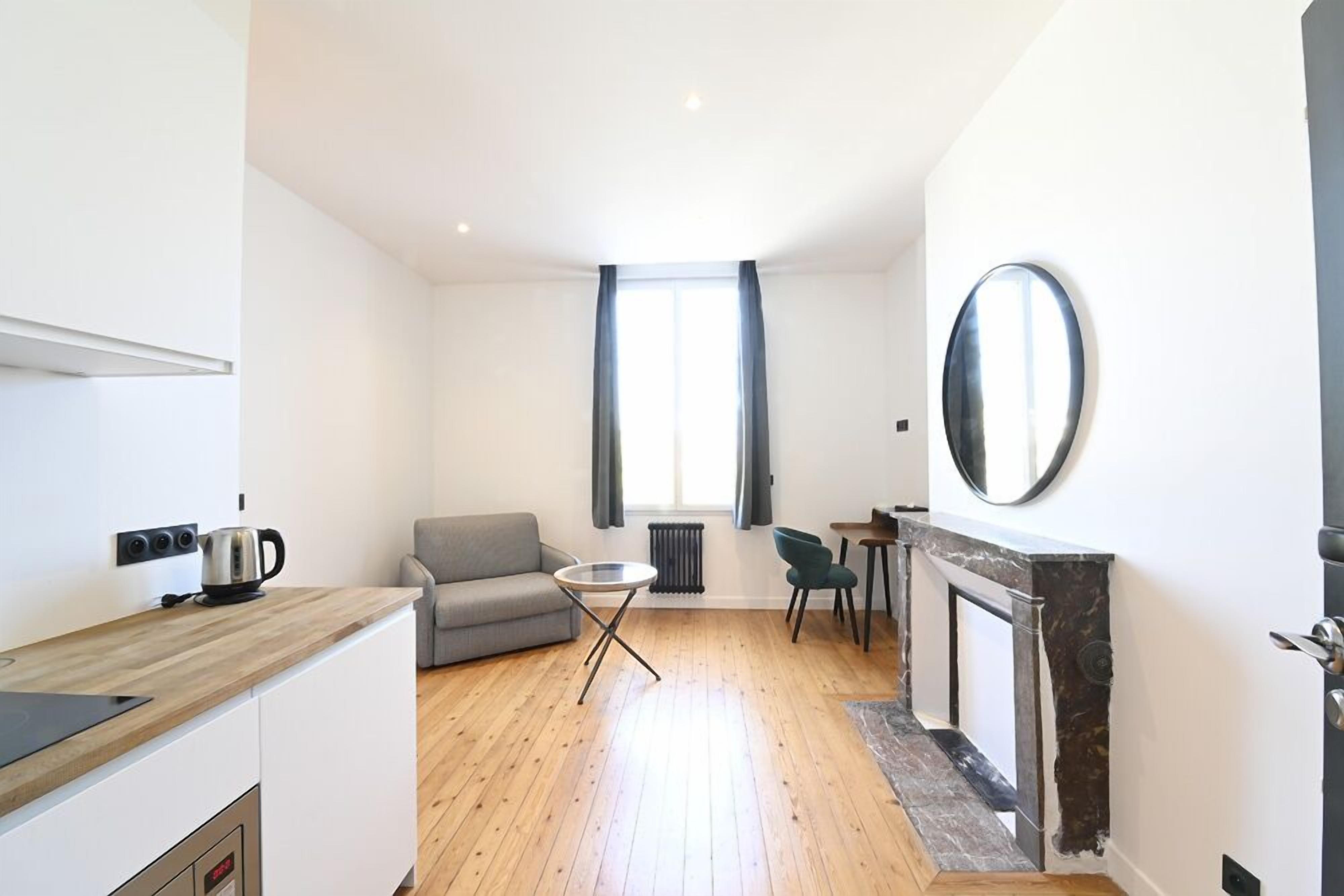 Un appartement moderne comprenant une cuisine, un coin repas et un salon.