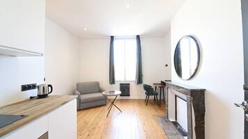 Un appartement moderne comprenant une cuisine, un coin repas et un salon.