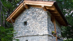 Un edificio de piedra con techo de madera y una ventana pequeña.