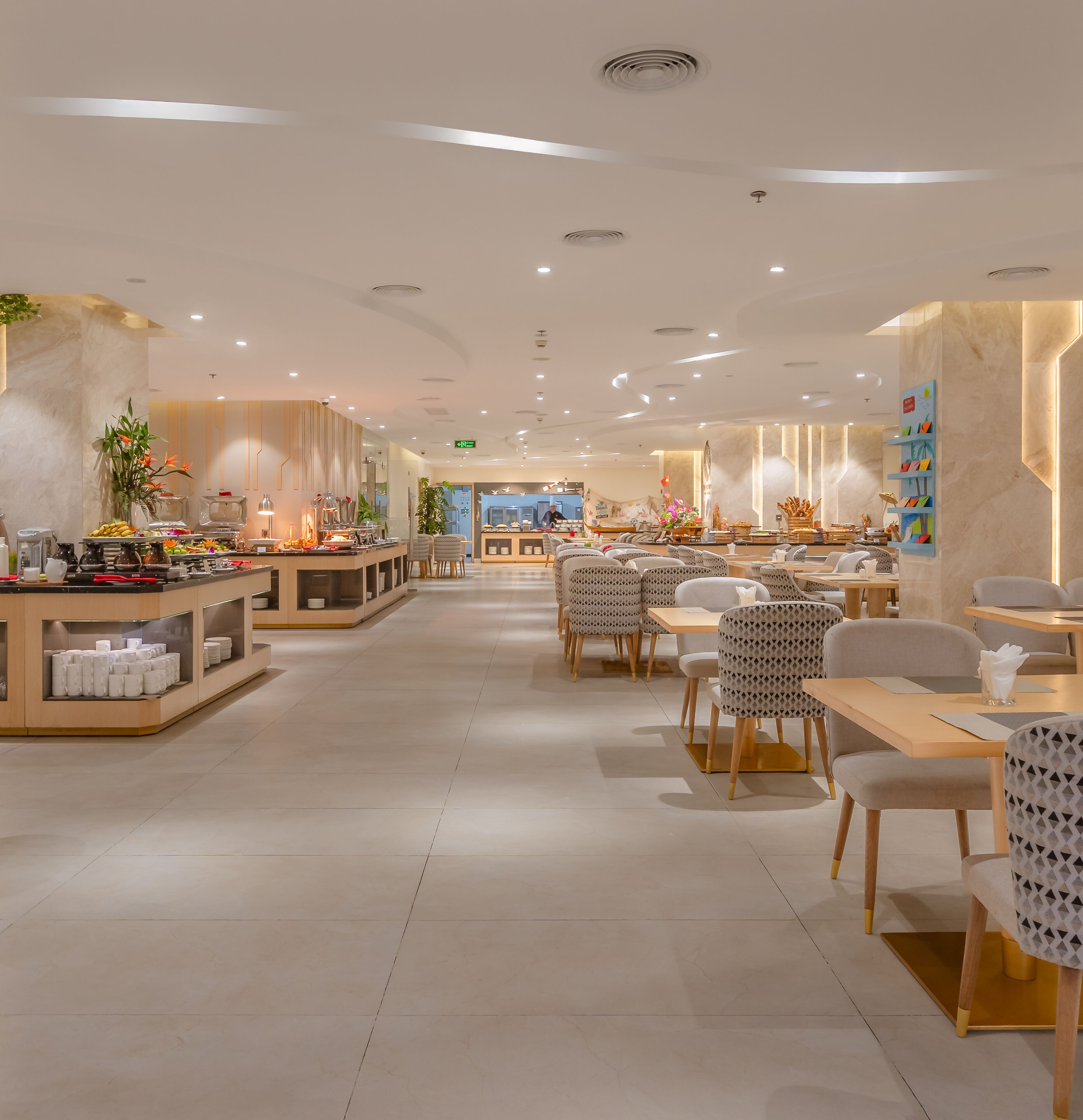 A spacious hotel lobby with a central buffet area, seating arrangements, and a modern design.