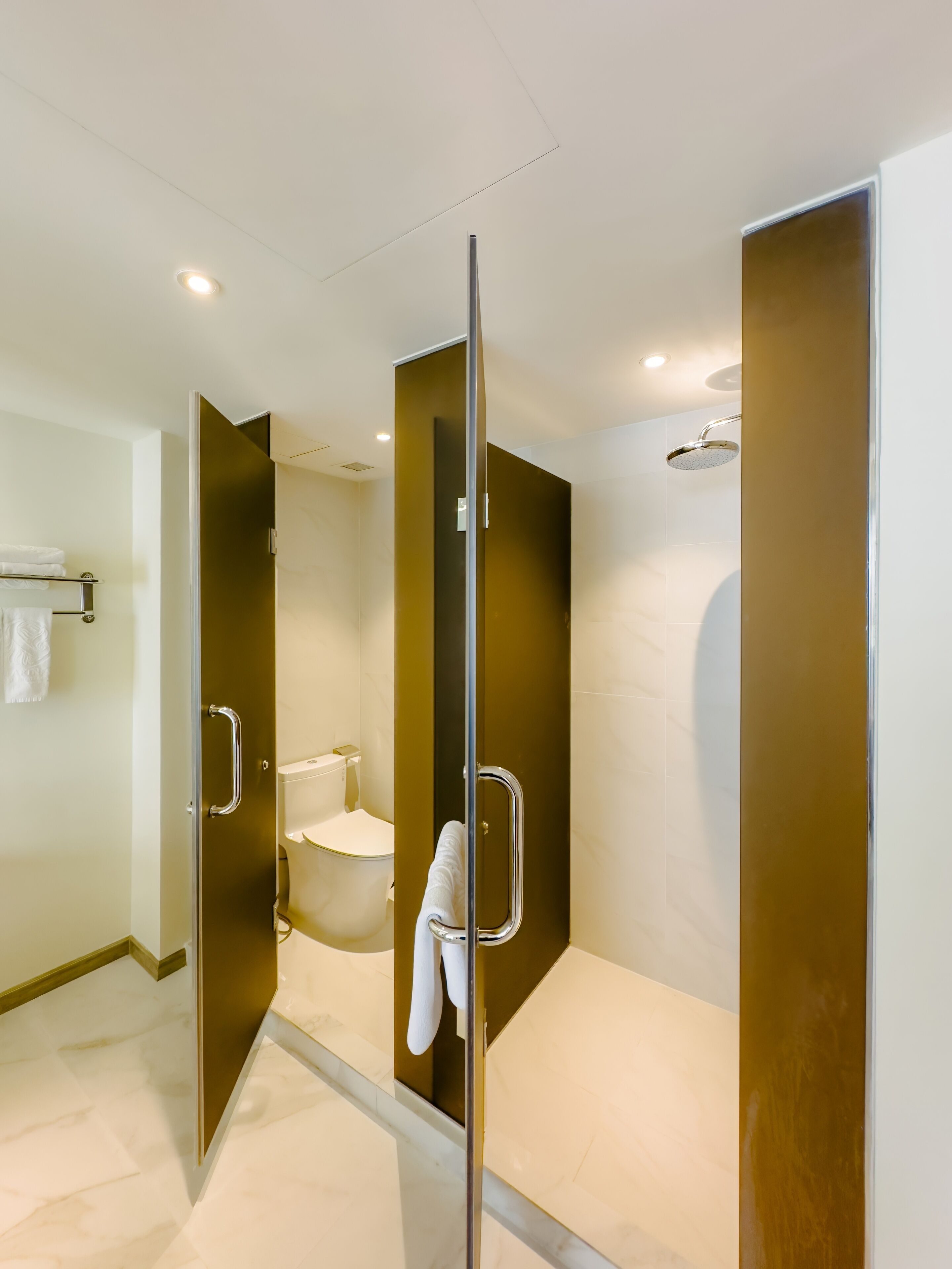 Un baño moderno con cabina de ducha de vidrio, inodoro y bañera.