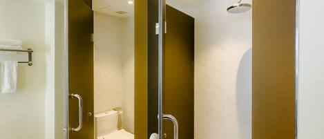 Un baño moderno con cabina de ducha de vidrio, inodoro y bañera.