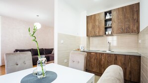 Una cocina moderna con armarios de madera, encimera blanca y una zona de comedor con mesa y sillas.