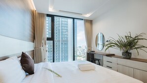A modern hotel room with a large bed, a desk, and a potted plant. - Shendo Vinhomes Metropolis (Hanoi)