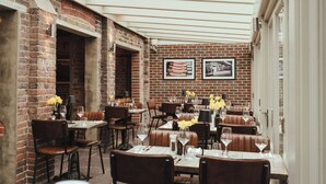 An indoor dining area with brick walls, wooden tables, and leather booths. - Winemaker's Pub (Cranbrook)