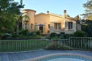 A Mediterranean-style house with a curved facade, a small balcony, and a tiled pool area. - Villa in an enclosed 3608 sq ft garden planted with trees (La Ciotat)