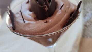 A dessert in a glass with chocolate decorations.