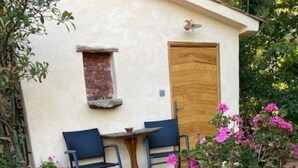 A small building with a wooden door, a window, and a table with two chairs outside. - Auberge U Sirenu (Sartene)