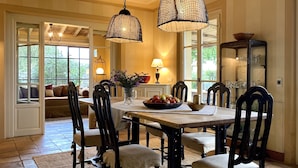 Comedor con mesa de madera, sillas y lámparas colgantes.