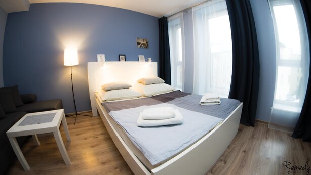 Quarto moderno com cama, mesa de cabeceira e abajur.