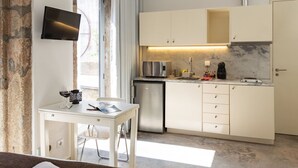 Eine moderne Küche mit weißen Schränken, einem eingebauten Backofen und einer Kaffeemaschine.
