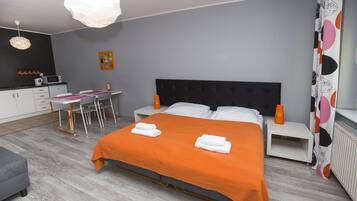 Un dormitorio con cama, mesitas de noche, escritorio y una silla.