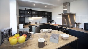 A modern kitchen with a central island, built-in appliances, and a sleek backsplash. - A SPIRIT OF FAMILY **** (4 ears) (Faudoas)